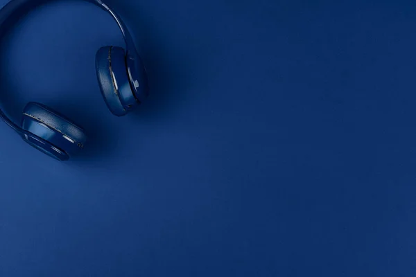 Fones de ouvido azuis no fundo azul, vista superior — Fotografia de Stock
