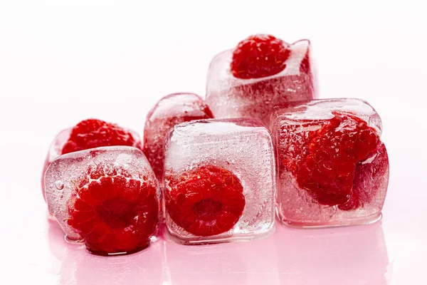 Kostki lodu malinowego na różowym, błyszczącym tle — Zdjęcie stockowe