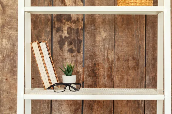 Close-up de estante branca contra parede de madeira grunge — Fotografia de Stock