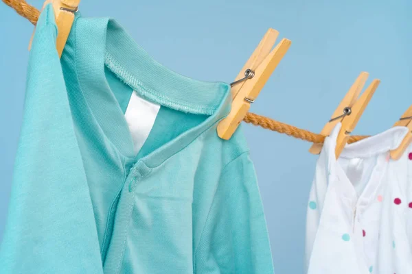 Leuke peuter kleurrijke kleding hangen aan een touw — Stockfoto