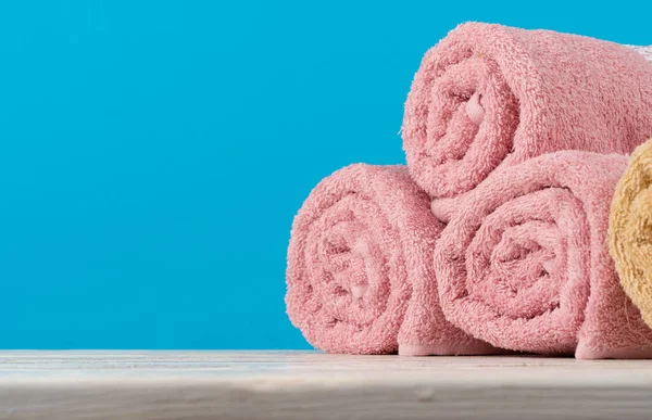 Pilha de toalhas enroladas em uma mesa de madeira — Fotografia de Stock