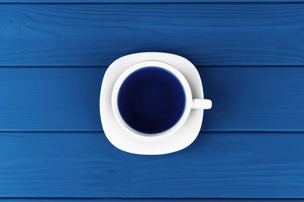 Vue du dessus d'une tasse de café sur soucoupe sur fond bleu classique — Photo