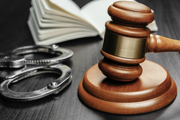 Коричневый деревянный судья молоток на фоне открытой книги