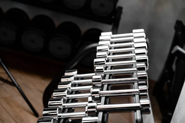 Linhas de halteres de metal no rack para musculação no ginásio — Fotografia de Stock