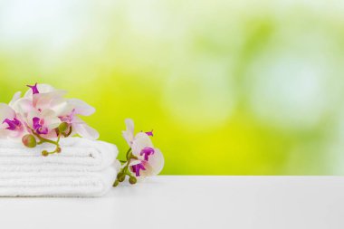 Bulanık arkaplana karşı ışıklı masada çiçekli havlular