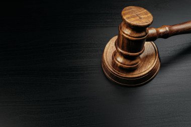 Judges gavel on wooden table in dark clipart