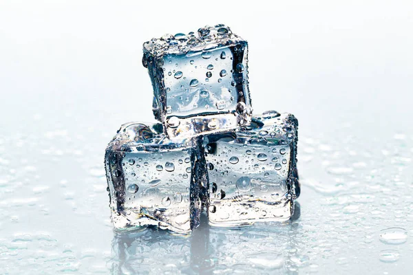 Vierkante smeltende ijsblokjes op natte tafel — Stockfoto