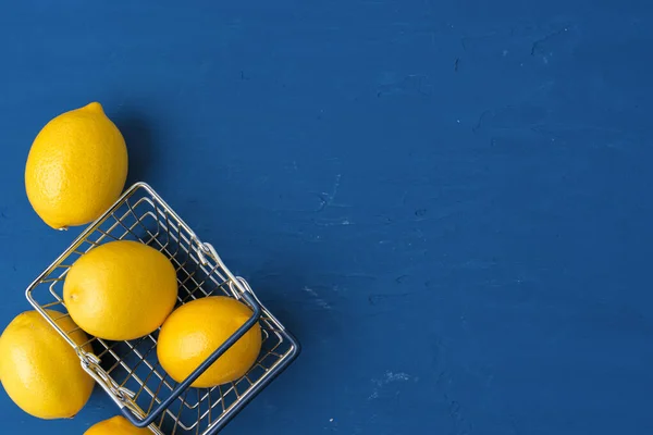 Limón en el carrito sobre fondo azul clásico, vista superior —  Fotos de Stock