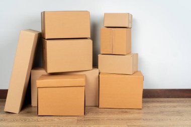 Tahta zeminde kahverengi karton kutular var.