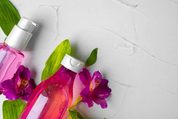 Μπουκάλι με άρωμα ή αρωματικό έλαιο σε ένα μπουκέτο φρέσκα λουλούδια — Φωτογραφία Αρχείου