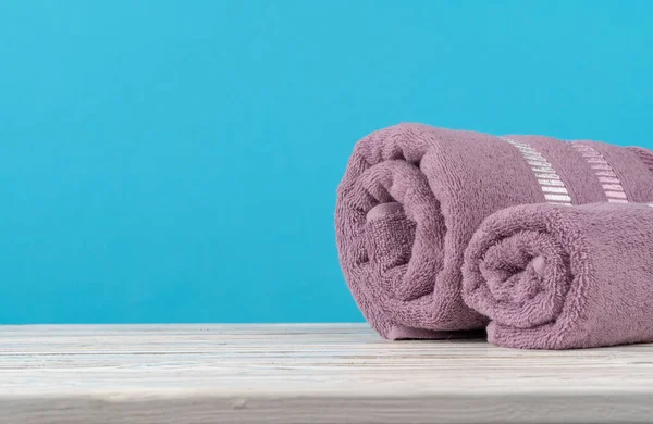 Stack of rolled towels on a wooden table — Stock Photo, Image