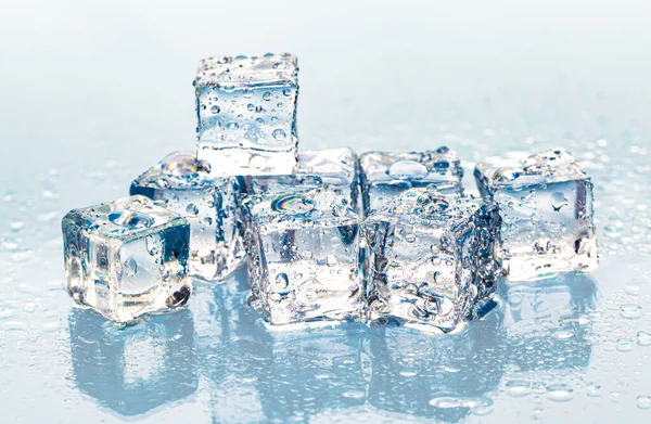 Cubos de hielo derretidos cuadrados sobre mesa húmeda —  Fotos de Stock