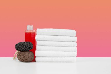 İstiflenmiş havlular ve spa taşlarıyla dolu bir spa.