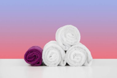 Renk arkaplanına karşı beyaz masaya temiz havlular istiflendi