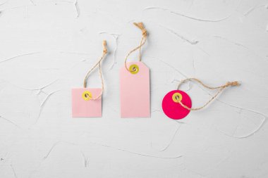 Gri arkaplanda boş pembe etiketler, üst görünümde