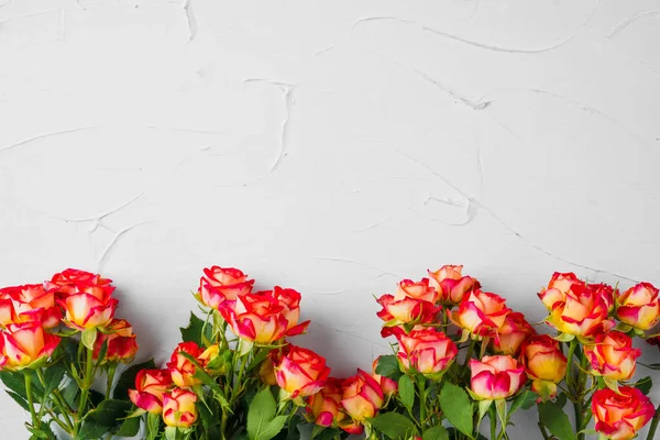 Pequeno buquê de rosas no fundo texturizado cinza claro com espaço de cópia — Fotografia de Stock