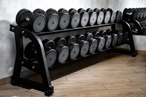 Reihen von Metallhanteln auf Rack für Bodybuilding im Fitnessstudio — Stockfoto