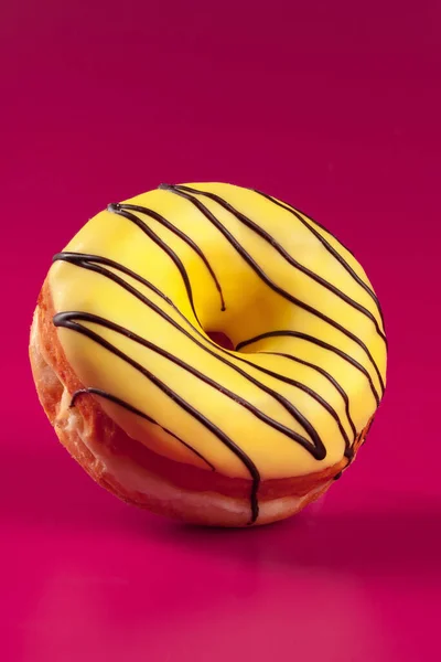 Lecker glasierter runder Donut auf leuchtend rosa Hintergrund — Stockfoto