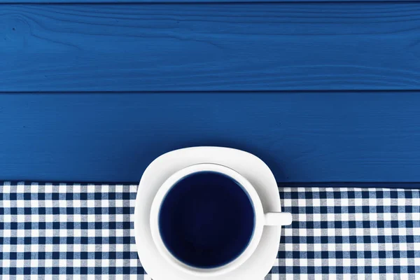 Top kilátás egy csésze kávé csészealj klasszikus kék háttér — Stock Fotó