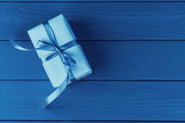 Mavi zemin üzerinde kurdele olan hediye kutusu, üst görünüm — Stok fotoğraf
