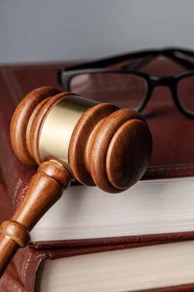 Bruine houten hamer met stapel boeken op grijze tafel — Stockfoto