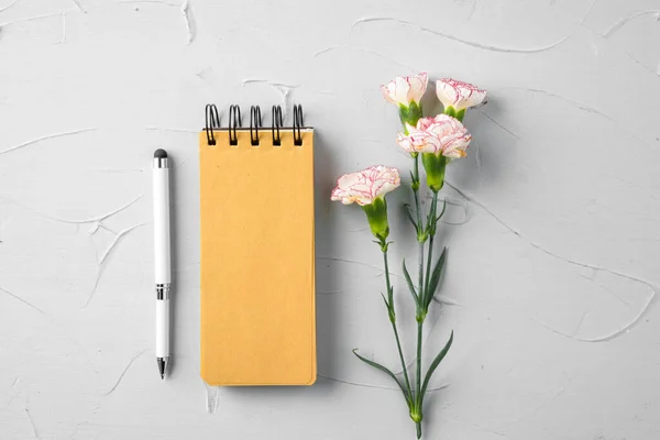 Página de bloco de notas em branco com ramo de flores, vista superior — Fotografia de Stock