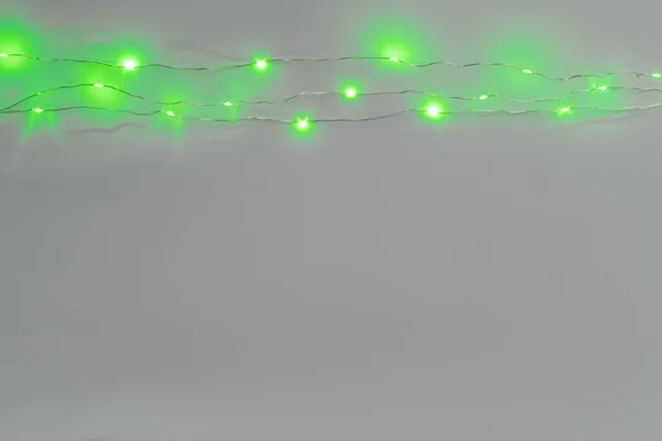 Cor verde iluminado guirlanda no fundo cinza claro — Fotografia de Stock