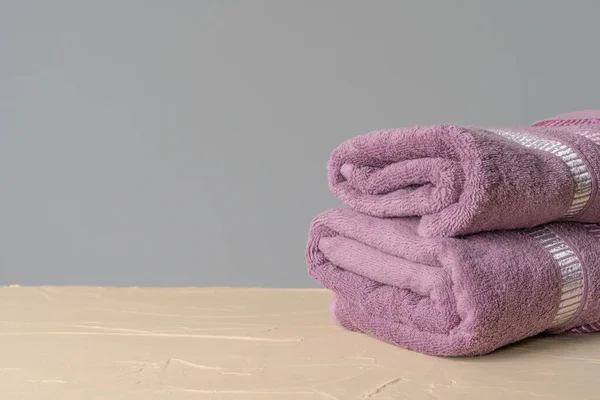 Συσκευασία καθαρές νέες πετσέτες ενάντια σε γκρίζο τοίχο — Φωτογραφία Αρχείου