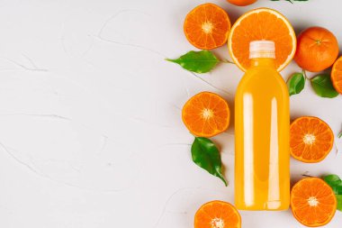 Olgun portakallı bir şişe portakal suyu.