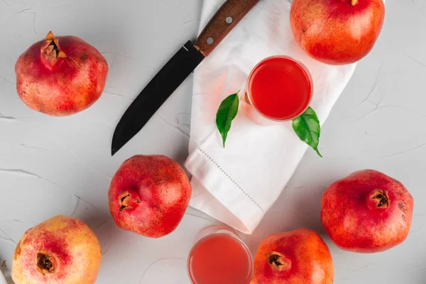 Glas Granatapfelsaft und Früchte auf einem Tisch — Stockfoto