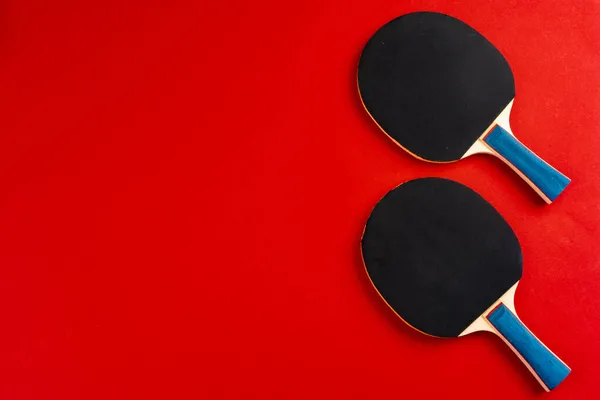 Fekete ping-pong ütők piros háttér — Stock Fotó