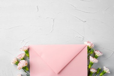 Üzerinde çiçekler olan pembe bir zarf. Romantik mektup