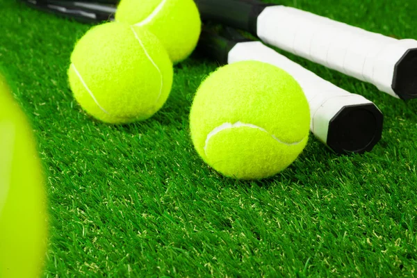 Tennisbollar på gräs på nära håll. Tennisutrustning — Stockfoto