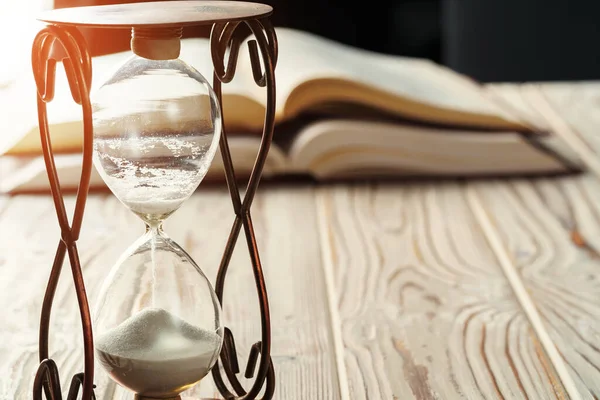 stock image Closed up of sandglass or hourglass on background of book