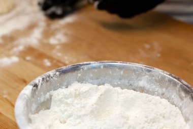 Şefin elleri siyah eldivenlerle hamuru hazırlıyor.