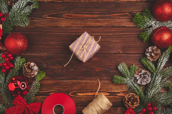 Stylowy prezent świąteczny ozdobiony wstążką na drewnianym tle, widok z góry — Zdjęcie stockowe
