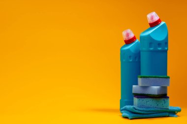 Sarı arka planda ev temizleme deterjanı şişeleri