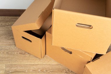 Tahta zeminde kahverengi karton kutular var.