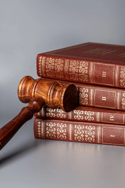 Bruine houten hamer met stapel boeken op grijze tafel — Stockfoto