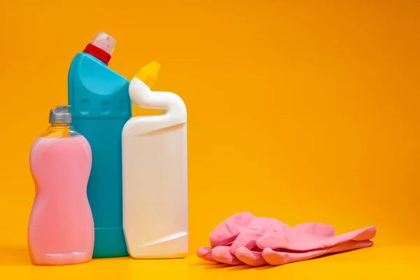 Butelki na detergenty do czyszczenia domów na żółtym tle — Zdjęcie stockowe