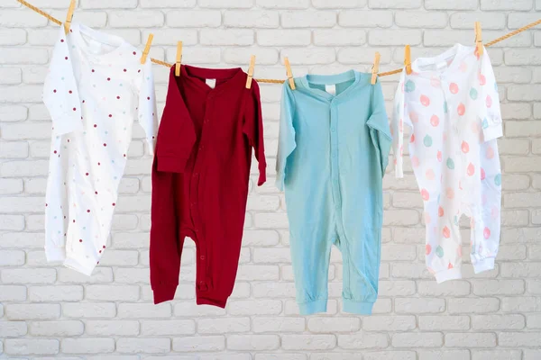 아기 옷을 말리기 위해 밧줄에 매단 채로 세탁 한다 — 스톡 사진