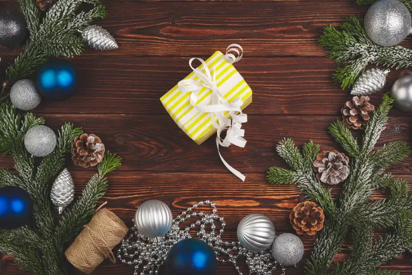 Stylowy prezent świąteczny ozdobiony wstążką na drewnianym tle, widok z góry — Zdjęcie stockowe