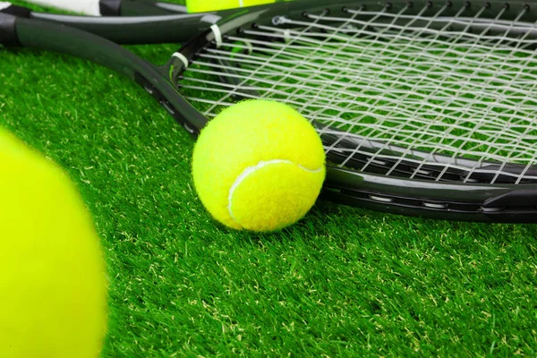 Tennisbollar på gräs på nära håll. Tennisutrustning — Stockfoto