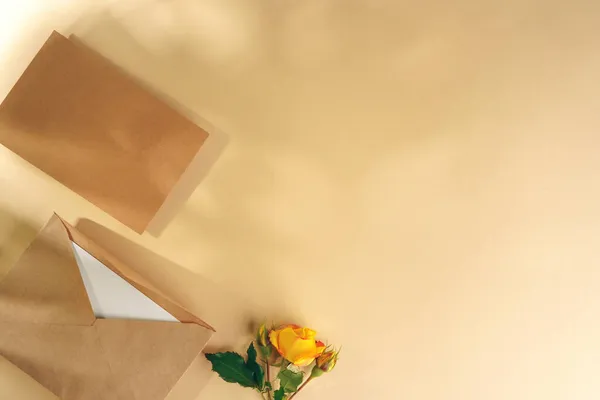 Паперовий конверт з жовтими трояндами на бежевому фоні — стокове фото