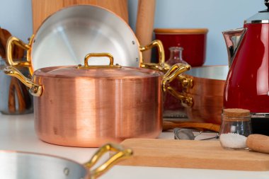 Temiz yemek takımları, modern mutfaktaki masaları kaplayan aletler.