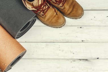 Grunge arka planında seyahat aksesuarları olan yürüyüş botları