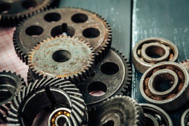 Araba parçaları, ahşap arka planda vites ve yataklar.