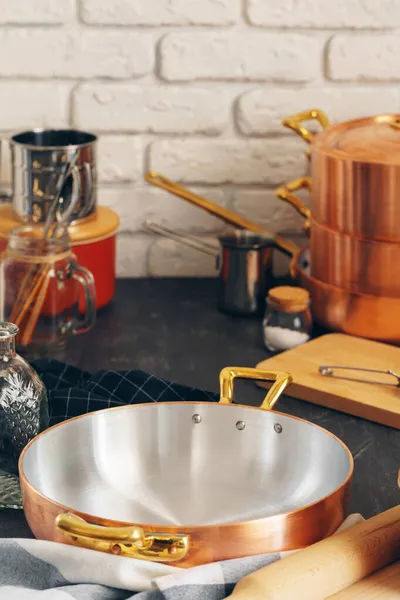 Pentole in rame con utensili da cucina in legno da vicino — Foto Stock