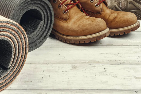 Hiking boots with travel accessories on grunge background — Stock Photo, Image