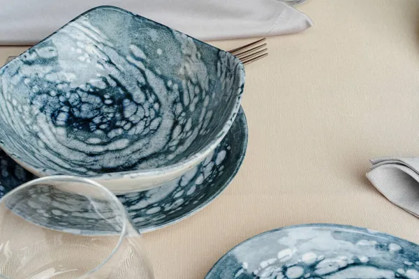 Детали стильной сервировки стола с текстурированной керамической посудой — стоковое фото